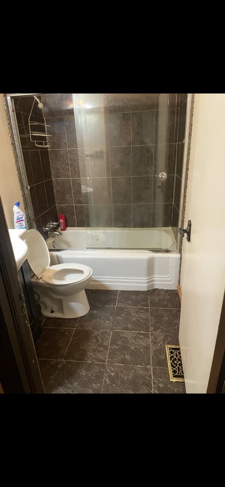 Bathroom after cleaning service with the tub, shower, and floor refreshed